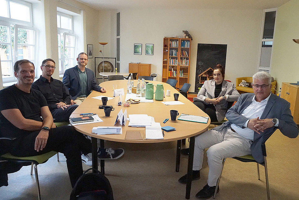 Fünf Personen in Gespräch am Besprechungstisch der Jugendhilfe