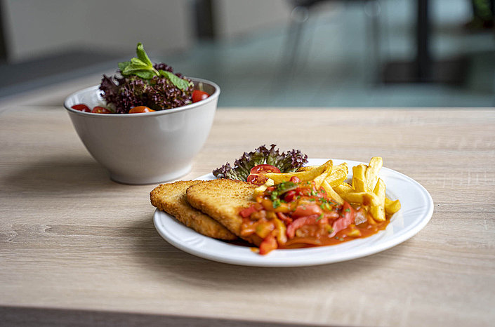 Teller mit panierten Schnitzeln, Pommes und Salat im Entdeckerbistro
