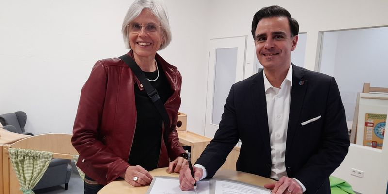 Zwei Personen unterschreiben Vertrag für neue Kita in Garbsen